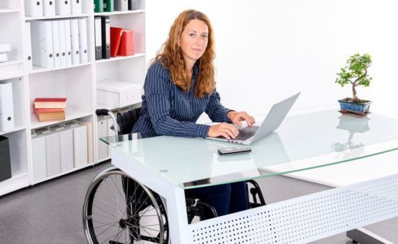 Mujer en silla de ruedas trabajando | BIGSTOCK